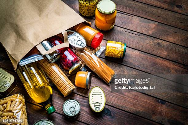 nicht verderbliche lebensmittel, die aus einer papiertüte kommen. kopierraum - canned goods stock-fotos und bilder