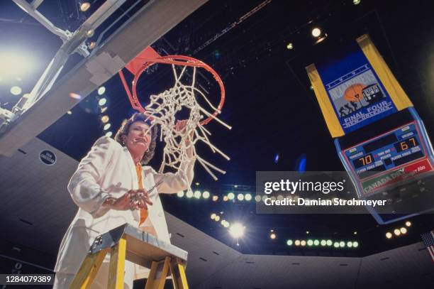 Pat Summitt, Head Coach for the Tennessee Lady Volunteers cuts the net on the backboard hoop to celebrate winning the NCAA Division I Women's...