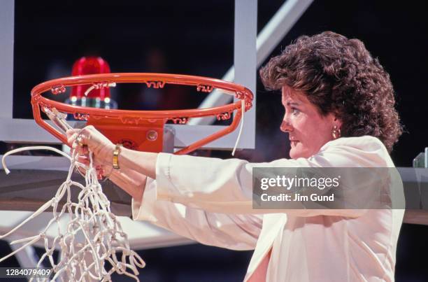 Pat Summitt, Head Coach for the Tennessee Lady Volunteers cuts the net on the backboard hoop to celebrate winning the NCAA Division I Women's...