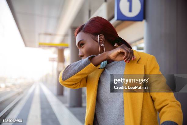 woman coughing at the train station platform - covering cough stock pictures, royalty-free photos & images