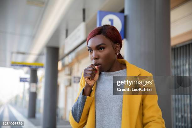 woman coughing at the train station platform - covering cough stock pictures, royalty-free photos & images