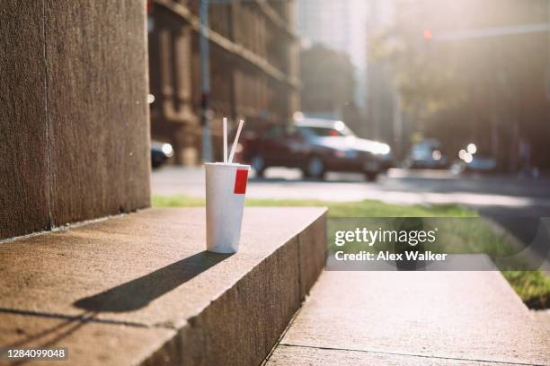 fast food drinks cup with straw on curb side in urban environment - sydney cup stock pictures, royalty-free photos & images