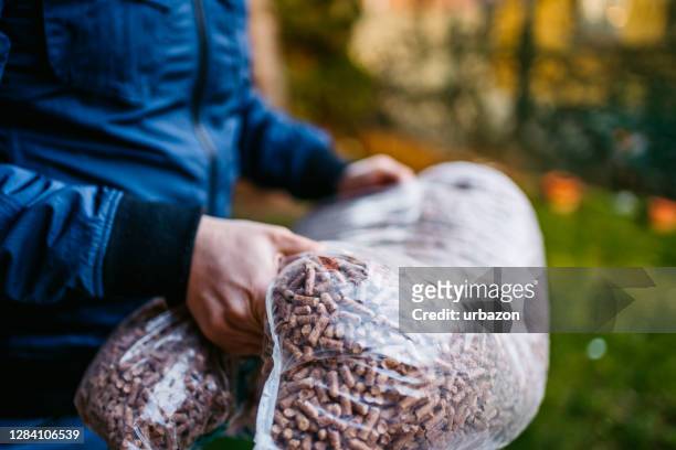 tragetasche mit pellets - biomasse stock-fotos und bilder