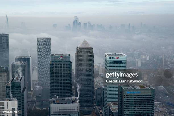 Fog shrouds the Canary Wharf business district including global financial institutions Citigroup Inc., State Street Corp., Barclays Plc, HSBC...