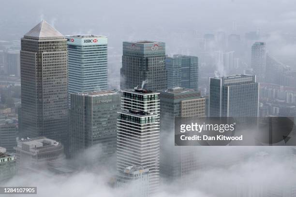 Fog shrouds the Canary Wharf business district including global financial institutions Citigroup Inc., State Street Corp., Barclays Plc, HSBC...