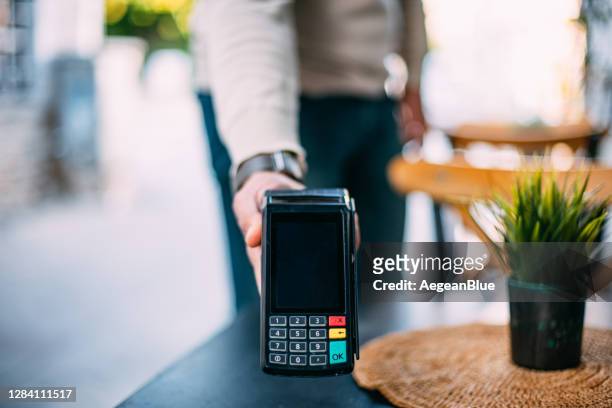 ober holding pos apparaat voor contactloze betaling - card reader stockfoto's en -beelden