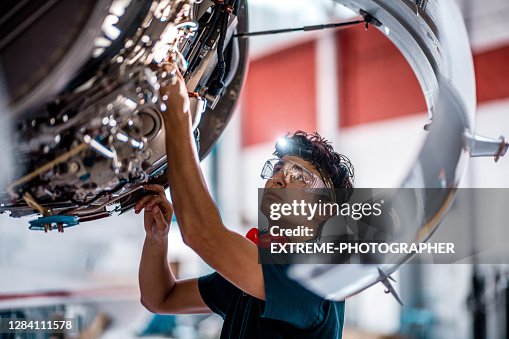 Meccanico aeronautico che controlla il motore a reazione dell'aereo Meccanico aeronautico che controlla il motore a reazione dell'aereo
