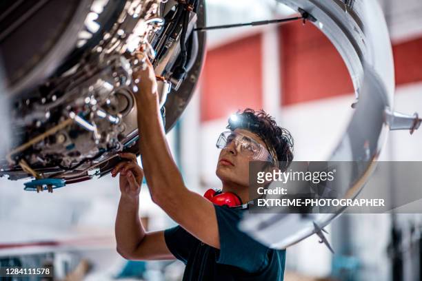 aircraft mechanic checking jet engine of the airplane - engineering imagens e fotografias de stock