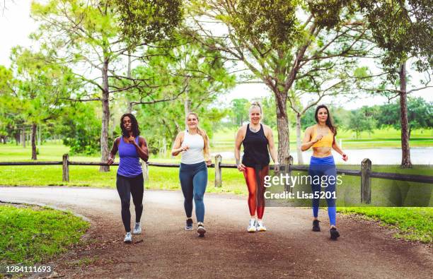 group of women power walking outdoors - walking stock pictures, royalty-free photos & images