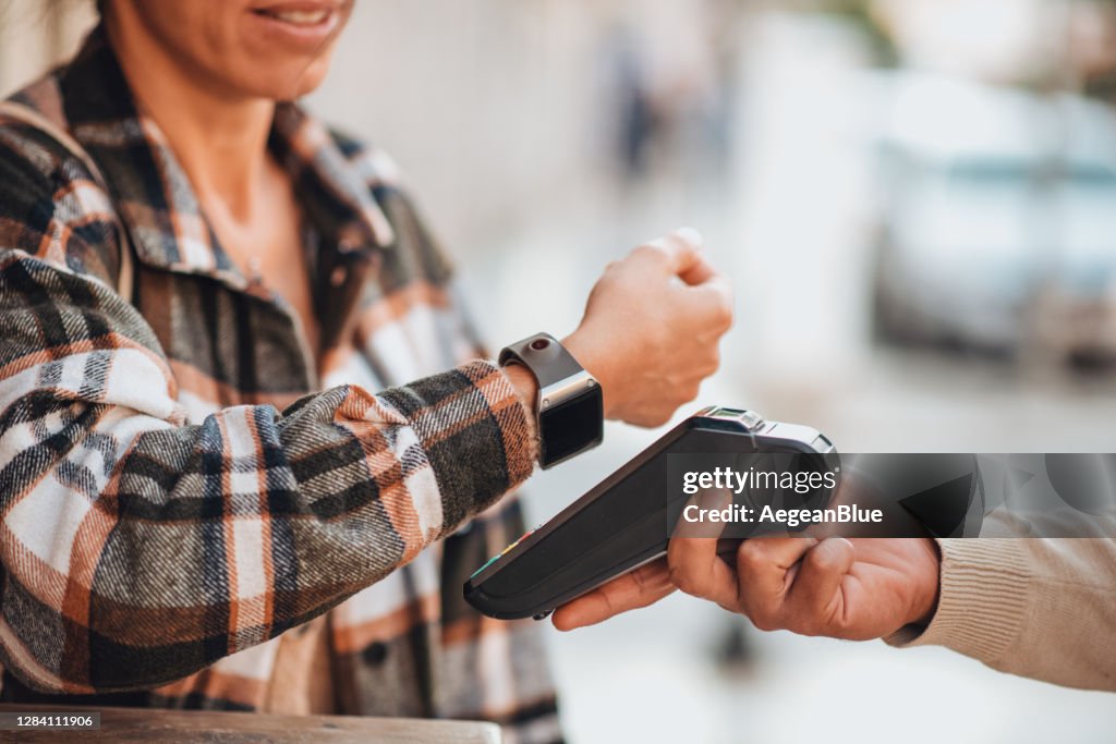 婦女使NFC支付與她的智慧手錶