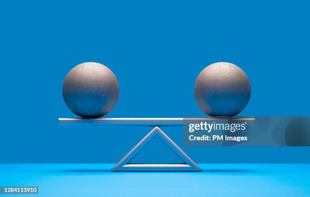 balls balancing on scale - compare size stockfoto's en -beelden
