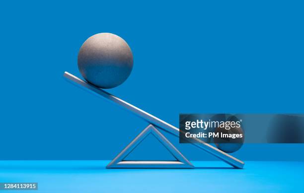 balls balancing on scale - ungleichgewicht stock-fotos und bilder