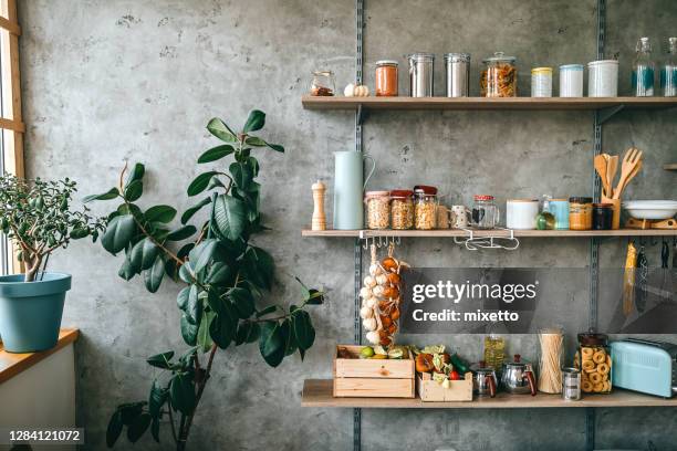 groceries in glass jars arranged on wooden shelves - jars on shelf stock pictures, royalty-free photos & images