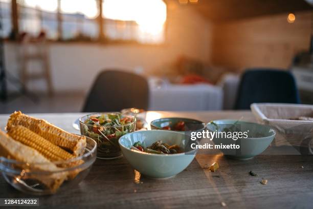 餐桌上帶玉米的沙拉碗 - messy table after party 個照片及圖片檔