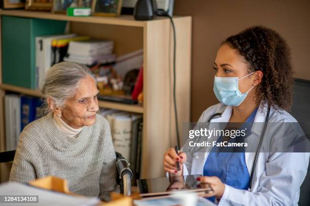 le patient médical âgé discute avec le docteur - centenaire et plus photos et images de collection