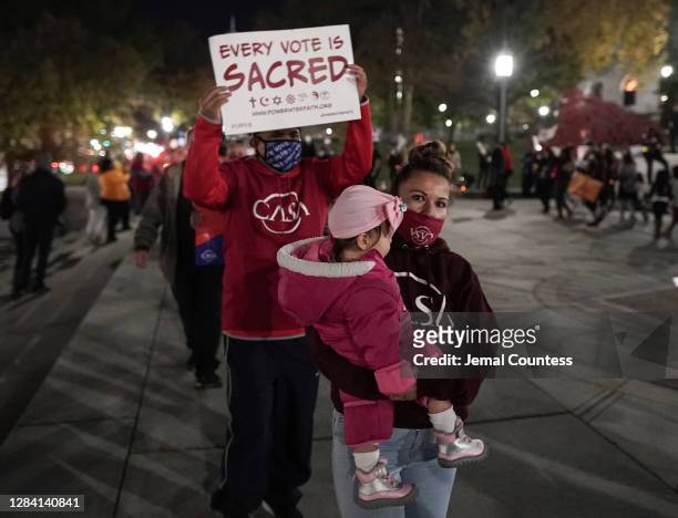 Mother and child march in a circle of protesters during a "Count Every Vote" demonstration at Pennsylvania State Capitol on November 05, 2020 in...