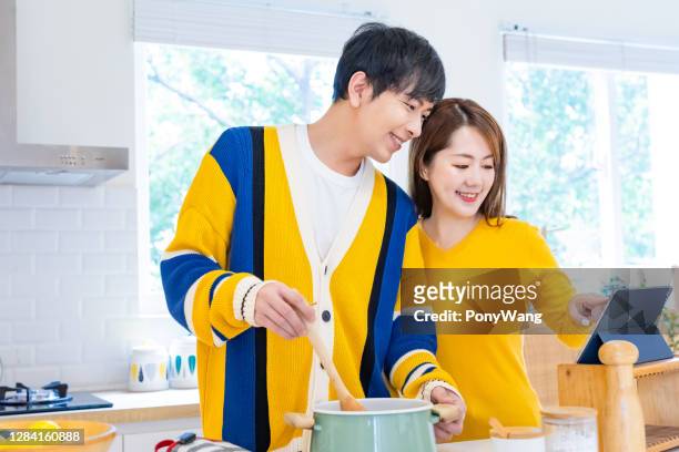 casal asiático cozinhar feliz - studio photo - fotografias e filmes do acervo