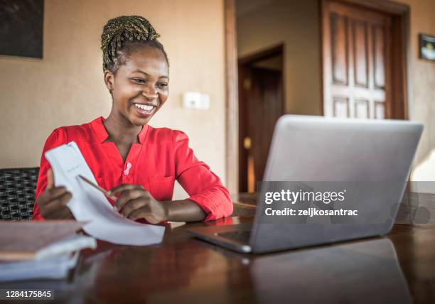 young black beautiful woman using laptop and phone - e learning africa stock pictures, royalty-free photos & images