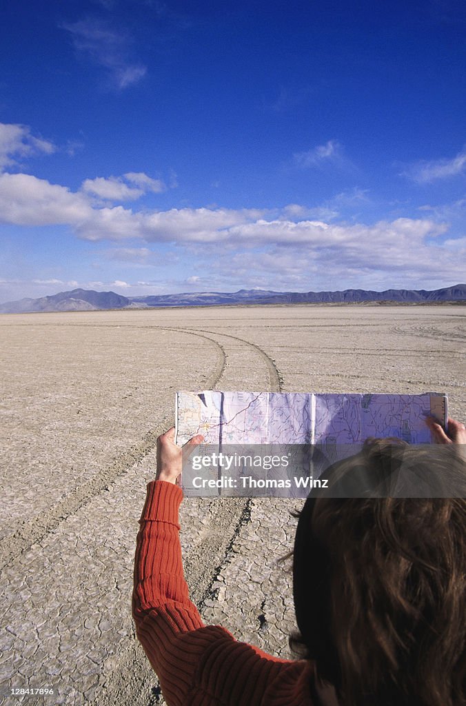 Woman looking at map, nevada desert