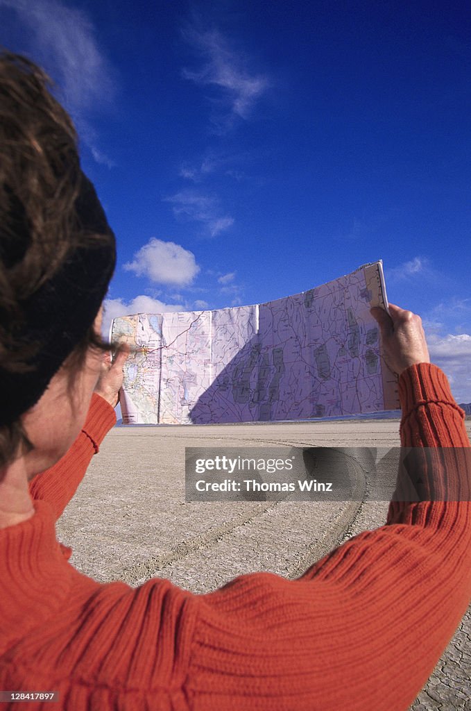Woman looking at map, nevada desert