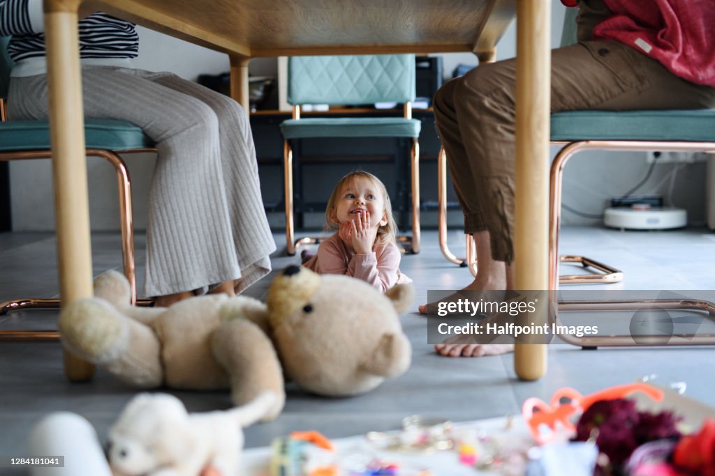 Small child with parents working from home, home office with kids concept.