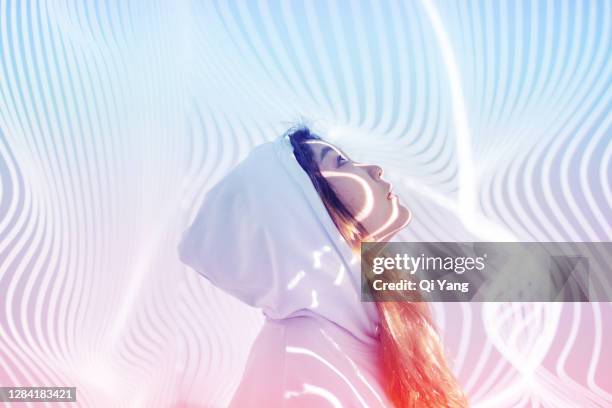 young woman standing in holographic background - colorful lights fotografías e imágenes de stock