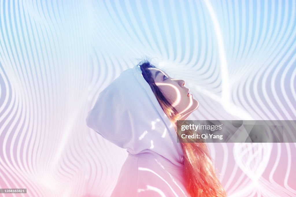 Young woman standing in holographic background