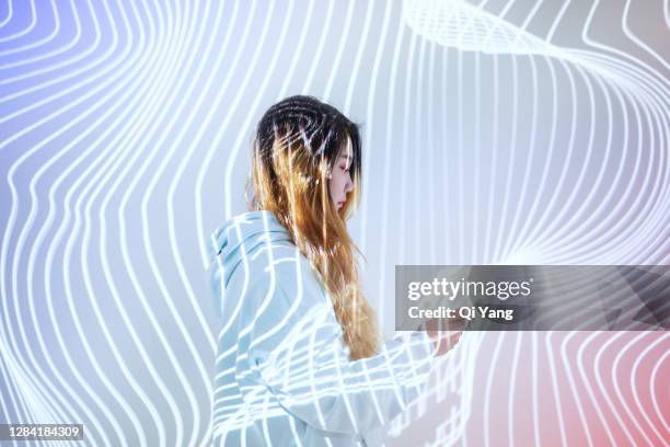 woman using mobile phone in the holographic background - smart people stock pictures, royalty-free photos & images