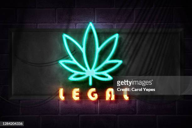 marijuana symbol  with legal text in neon lights - cannabis store stockfoto's en -beelden