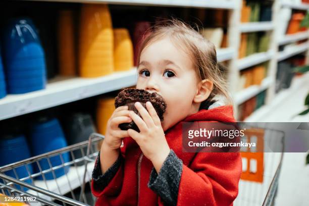 kleine süße mädchen essen ungesunde schokolade cupcake - sharing chocolate stock-fotos und bilder