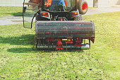 Gardener Operating Soil Aeration Machine on Grass Lawn