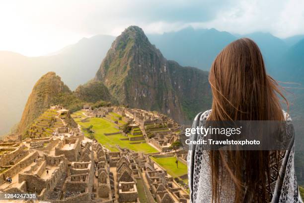 girl looking down on machu picchu peru, south america - machu pichu stock pictures, royalty-free photos & images