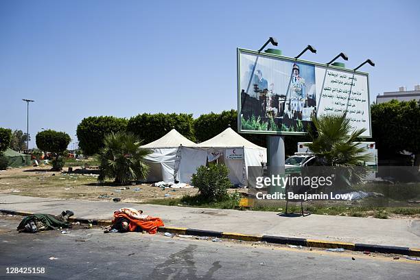 The bodies of two recently killed pro-Gaddafi loyalists lie on a sidewalk outside an abandoned medical encampment near the south entrance of the Bab...