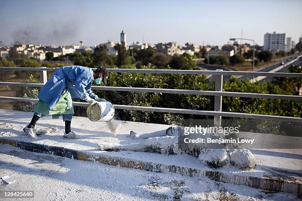 Medical volunteer spread lime over the body of a dead Libyan, the victim of a sniper, on an overpass in the Abu Salim neighborhood on August 26 2011...
