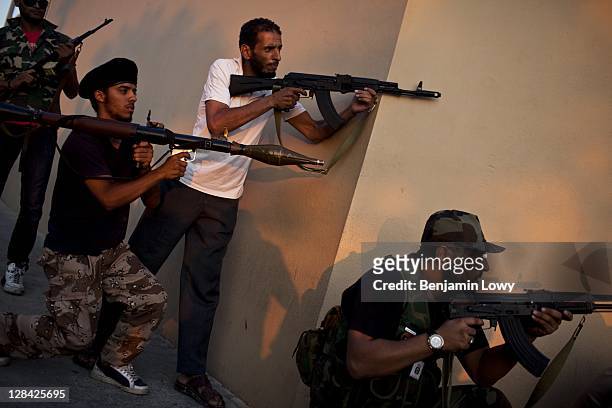 Libyan Rebels aim their weapons at a suspected Gaddafi loyalist sniper who targeted the Corninthian hotel, home to a large cadre of international...