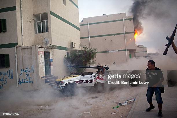 Libyan rebels destroy their own vehicle as they fire a 40mm recoiless rifle at a building housing a Gaddafi loyalist sniper in the dangerous Abu...