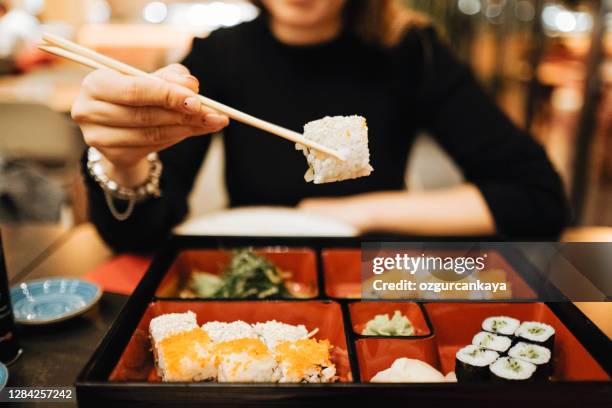 picking up a sushi piece with chopsticks - sushi bar stock pictures, royalty-free photos & images