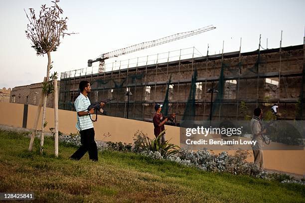 Libyan Rebels aim their weapons at a suspected Gaddafi loyalist sniper who targeted the Corninthian hotel, home to a large cadre of international...