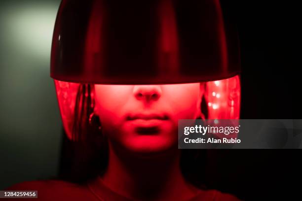 young girl applying a led light treatment to her hair. - luce led foto e immagini stock