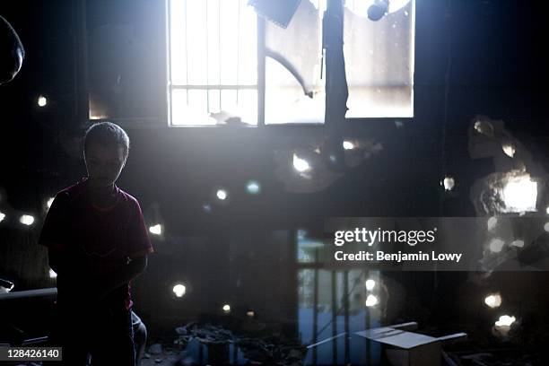 Libyan boy helps his father as they pick through an apartment in a building targeted by Rebel forces during a violent confrontation with Gaddafi...