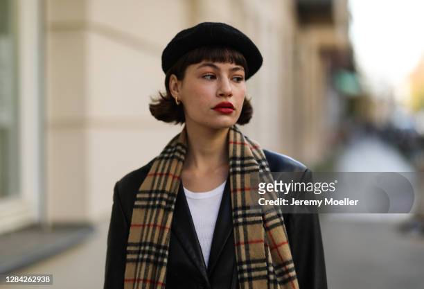 Lea Naumann wearing vintage black coat, Burberry scarf, H&M hat on November 05, 2020 in Berlin, Germany.