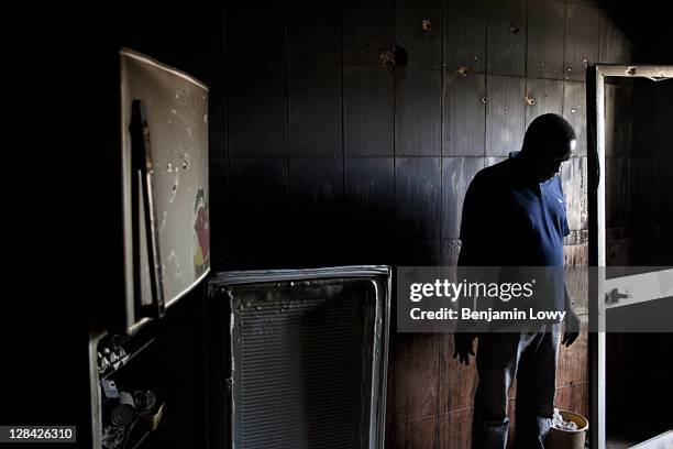 Libyan stands in the destroyed remains of an apartment kitchen in a building targeted by Rebel forces during a violent confrontation with Gaddafi...