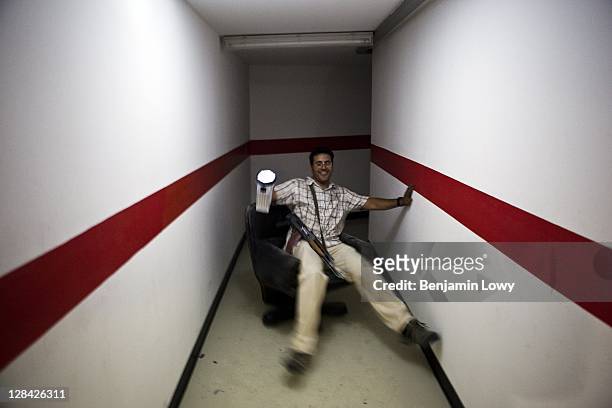 Libyan rebels rides a wheeled office chair through secret underground tunnels in the looted and NATO bombed home of former Libyan dictator Moammar...