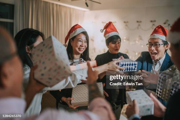 asiatiska kinesiska kontor kollega utbyte julklapp firar julfest efter att ha arbetat timme i office lounge - exchanging bildbanksfoton och bilder