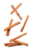 Cinnamon sticks fly and fall on a heap on a white background. Isolated