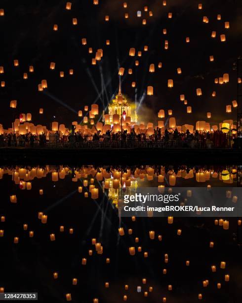 yi peng festival with rising lanterns and a reflection in the lake, chiang mai, thailand - lantern water stock-fotos und bilder