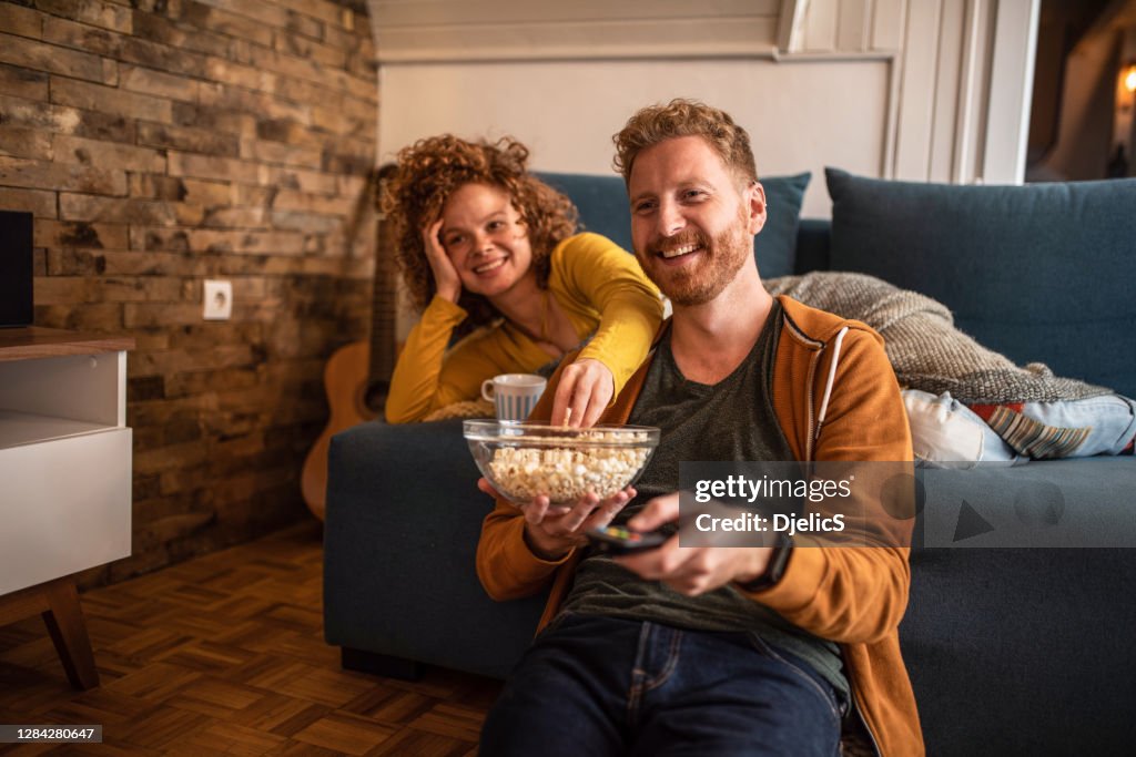 Young couple watching a movie at home.