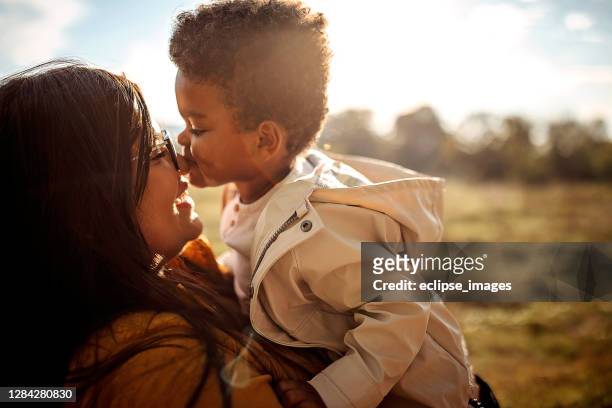 madre multiéttica e hijo pasan tiempo juntos al aire libre - mixed race family fotografías e imágenes de stock
