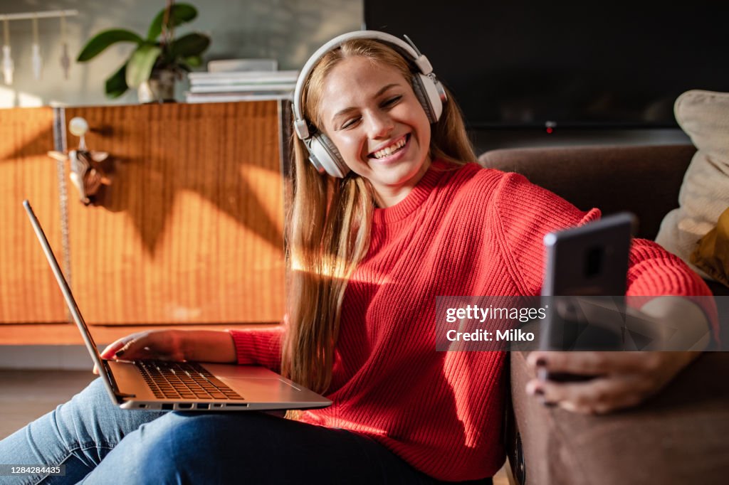 Woman Using Technology Simple A Young Cheerful Woman Is Using Technology At Home High-Res Stock Photo ...
