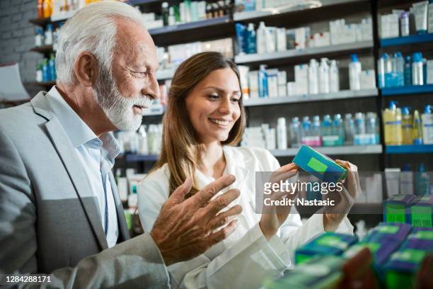 female pharmacist giving instructions for medications to senior customer - pharmacist and patient stock pictures, royalty-free photos & images